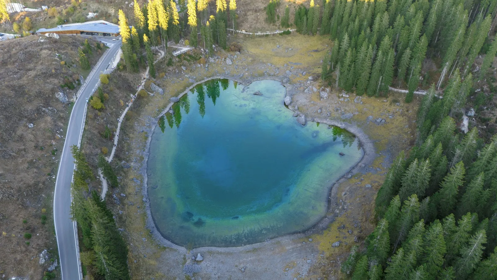 Route de col dans les Dolomites en octobre, mélèzes dorés et parois rocheuses